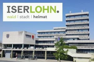 Im Hintergrund ist das Rathaus der Stadt Iserlohn zu sehen. Im Vordergrund das Logo der Stadt.